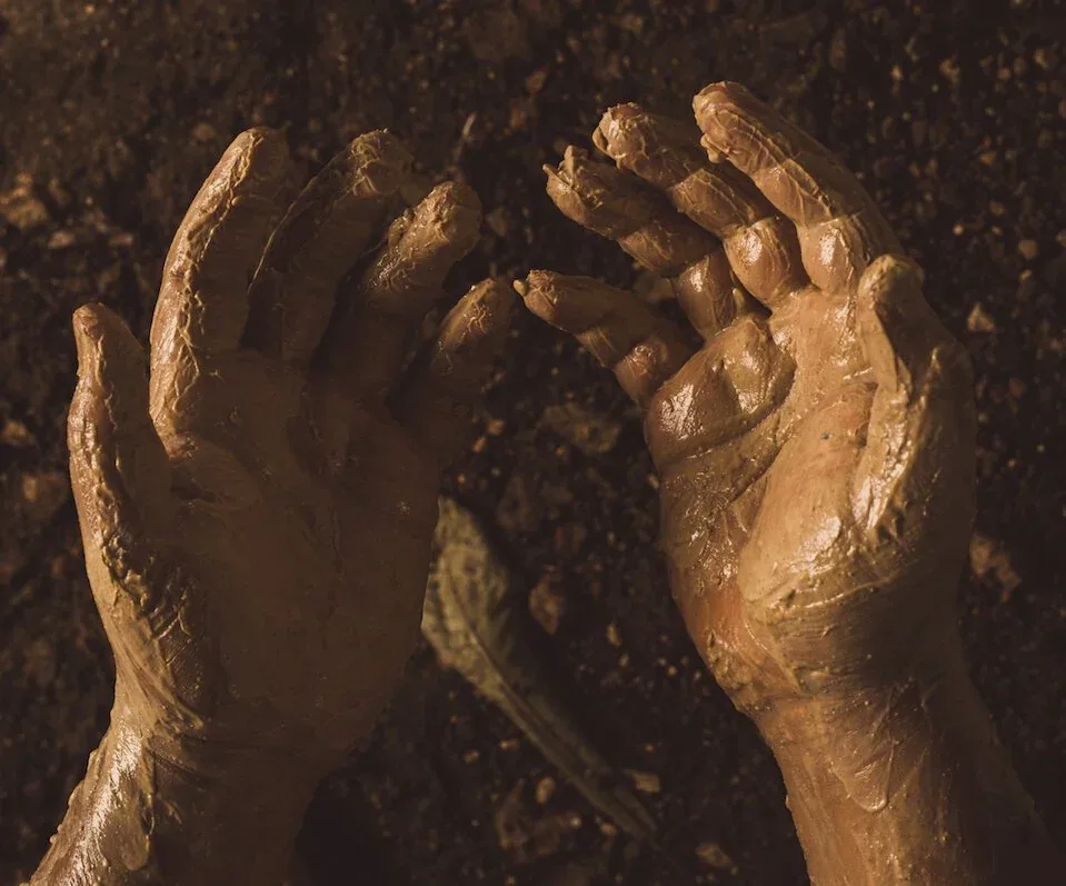Hands pressing raw clay taken from the earth