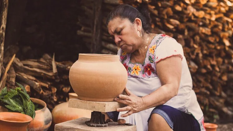 Mujer trabajando alfarería al aire libre en el taller de la familia Espadas
