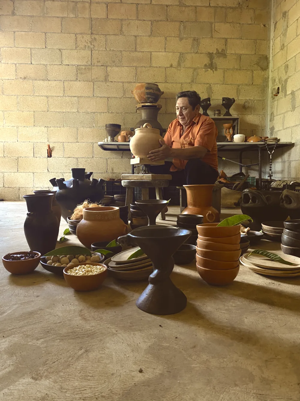 Don Emilio in the family workshop surrounded by finished clay vessels