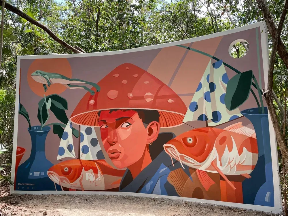 Site specific artwork at Holistika Art Walk produced by Tulum Art Club, showing a figure with a red mushroom cap surrounded by fish and frogs.