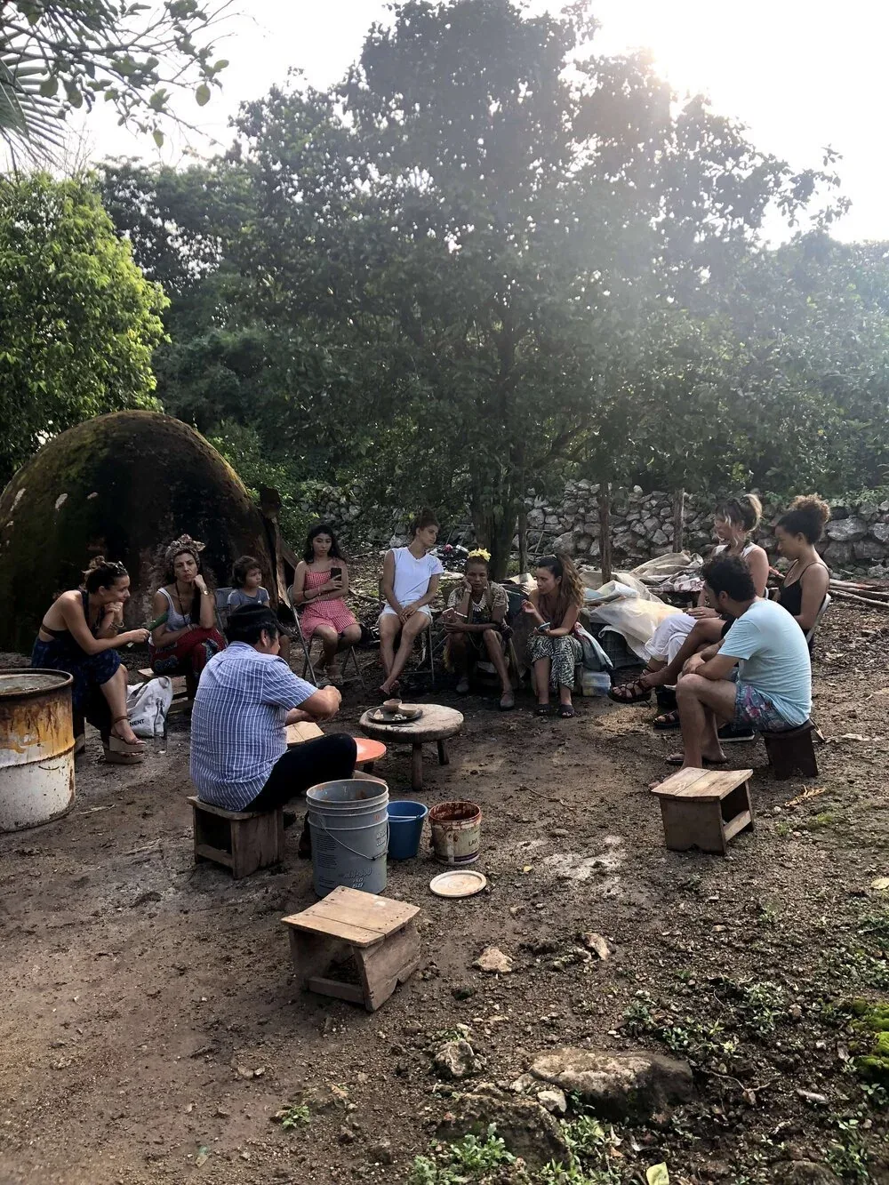 Visitors seated outdoors listening to an introduction about Mayan clay